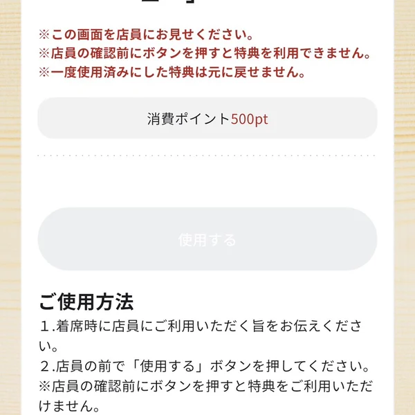 スシロー公式アプリの特典画面。店員の前で使用するボタンを押すよう案内している